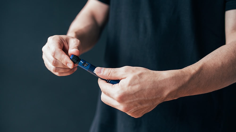 man holding insulin pen