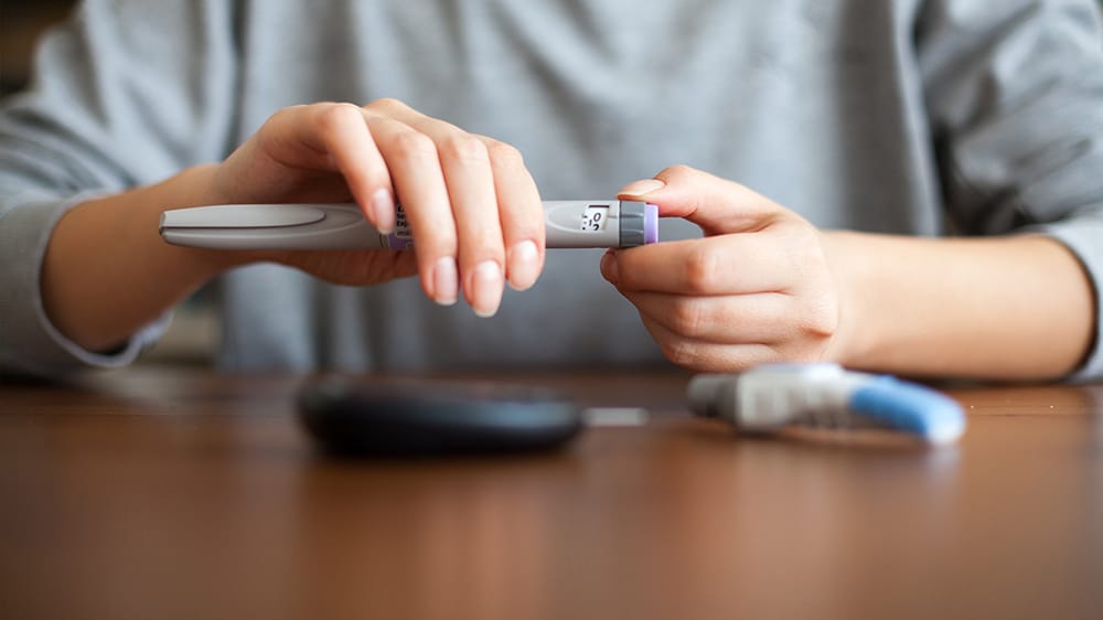 starting insulin, woman at desk with insulin pen