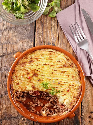 Cottage pie in a bowl, with a serving already taken out of it