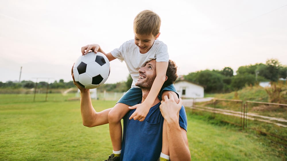 Man and child playing football