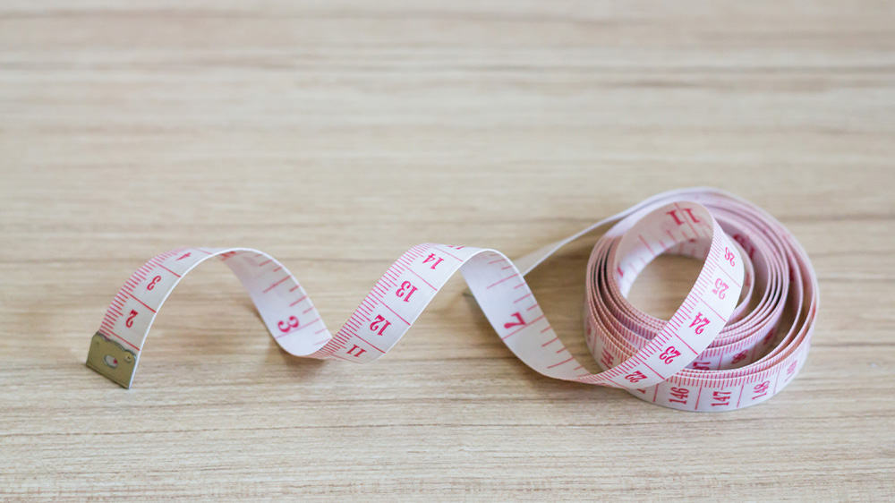 measuring tape sitting on pale wooden table