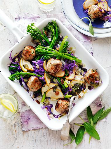 Pork and sage meatballs in a serving dish with broccoli and red cabbage