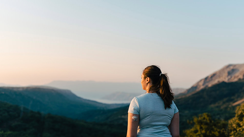 Young woman outdoors with CGM on her arm