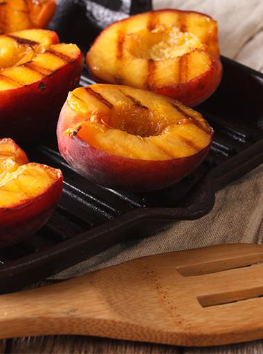 Grilled Fruit halved peaches on a baking tray