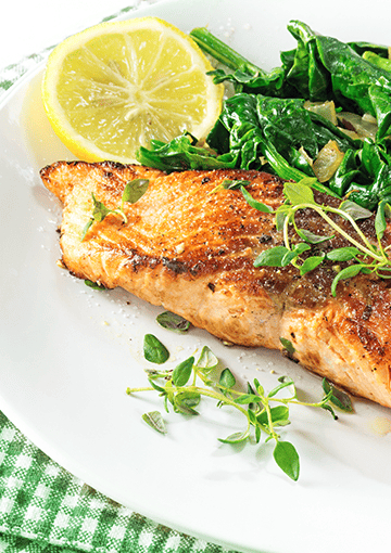 baked salmon with lemon and herbs on a white plate