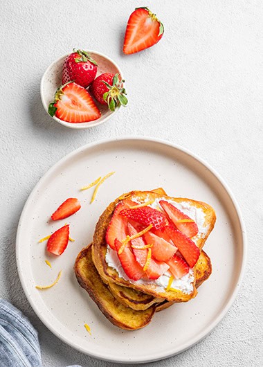Toasted bread with cream cheese and strawberries.