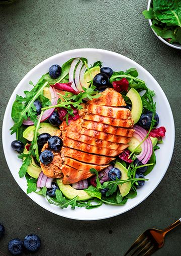 Summer salad with chicken on a plate, ready to be eaten