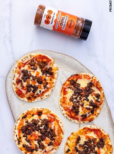 Taco pizzas arranged on a plate, with Mingle seasoning next to plate