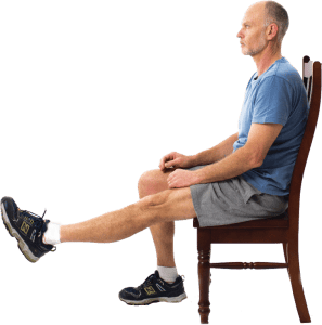 man sitting on chair with left leg raised out in front