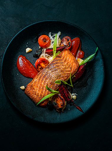 Baked salmon with vegetables placed on a plate, ready to eat