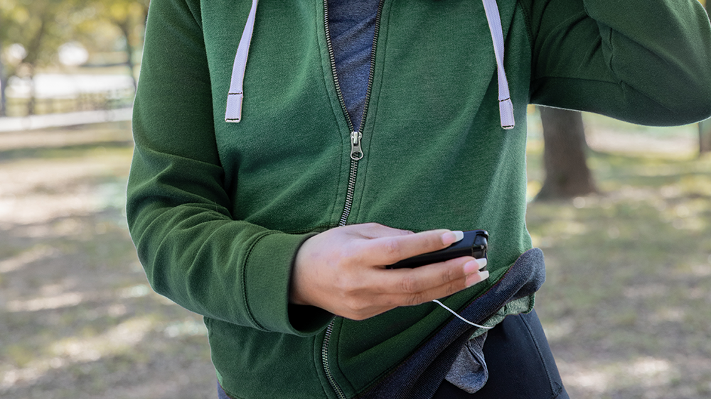 close up of a woman in a green top looking at her pump