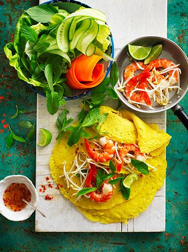 Vietnamese pancakes with prawns herbs and lime garnish