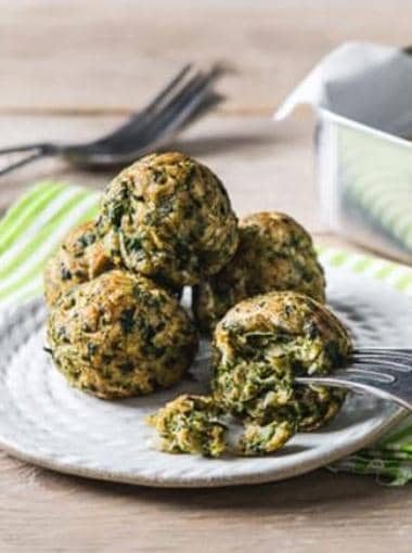 Spinach Balls stacked on a plate with a fork