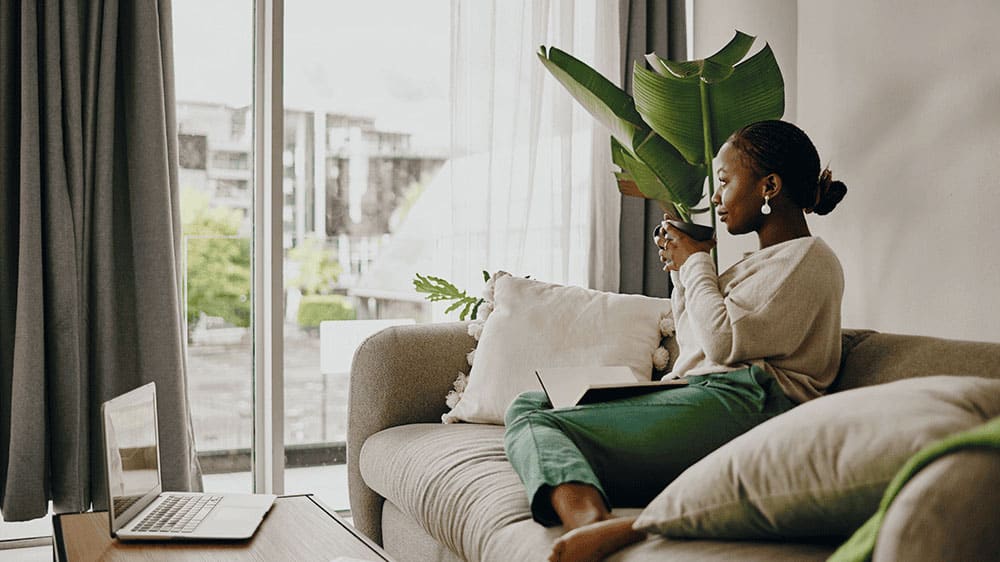 woman drinking tea and looking out of a window