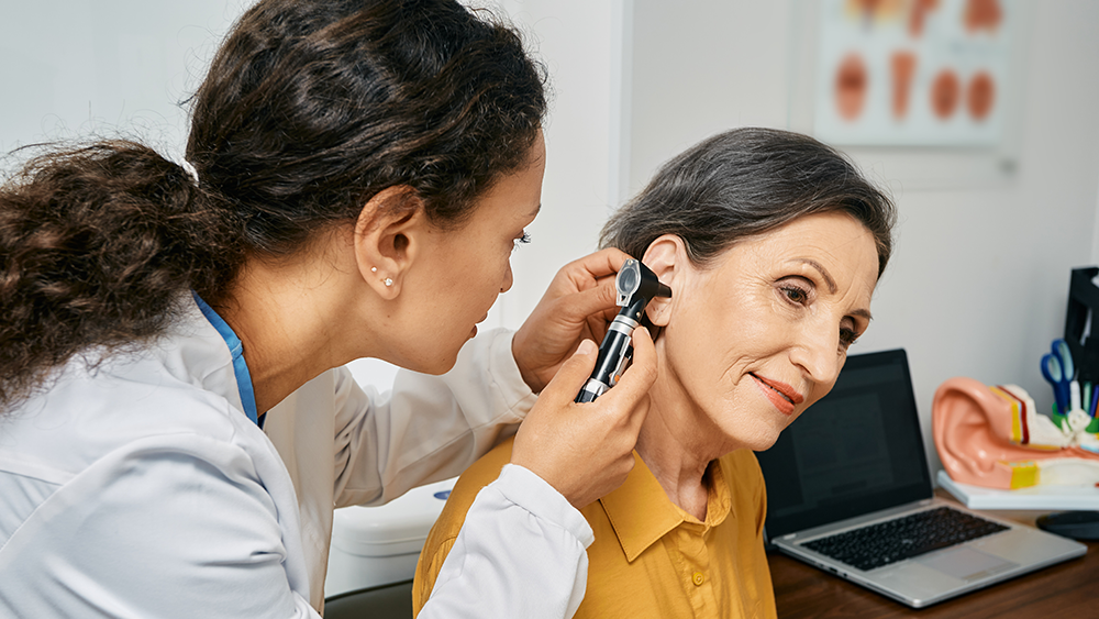 woman in yellow top having her ears checked