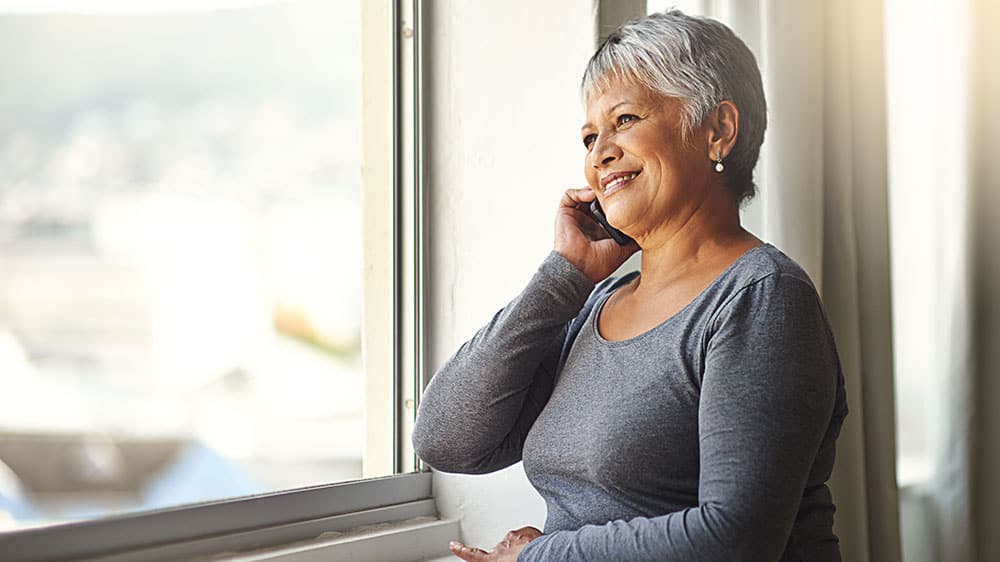 Woman smiling, at home on a phone call