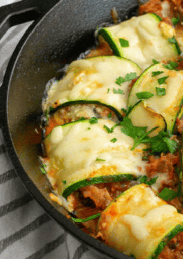 zucchini bake topped with basil in a black serving bowl